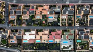 an aerial view of a city with lots of houses by Pau de Valencia courtesy of Unsplash.