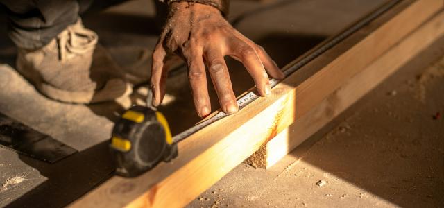 A man using a circular saw to cut a piece of wood by infinity lifespaces courtesy of Unsplash.
